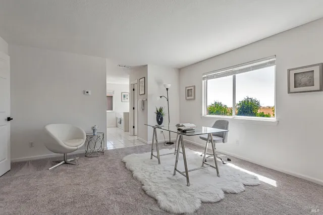 a spacious bedroom with a large bed and a chandelier