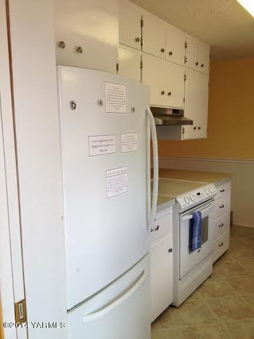 910 Willowlawn Road Yakima, WA 98908 - Photo 12 of 39 a kitchen with stainless steel appliances white cabinets and wooden floors