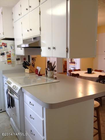 910 Willowlawn Road Yakima, WA 98908 - Photo 7 of 39 a kitchen with stainless steel appliances granite countertop a sink a stove and a refrigerator