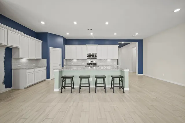a kitchen with stainless steel appliances granite countertop a sink stove and cabinets