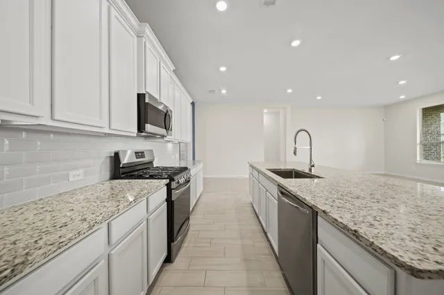 a kitchen with stainless steel appliances granite countertop a sink and a stove