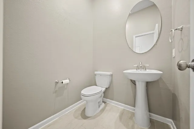 a bathroom with a sink toilet and a mirror