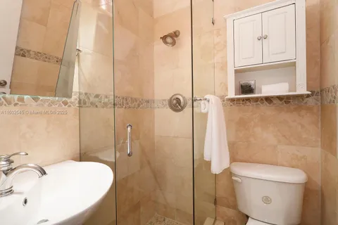 a bathroom with a sink a toilet and shower