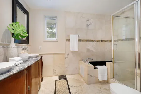 a bathroom with a granite countertop sink a toilet and shower