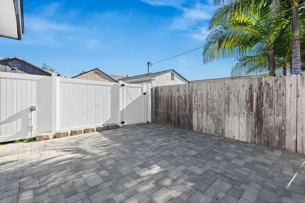 a view of a house with a backyard and wooden fence
