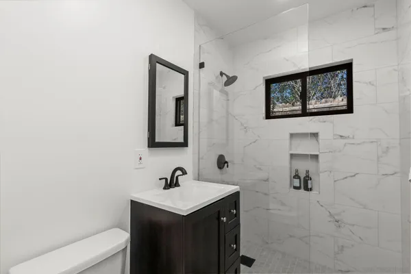 a bathroom with a toilet sink and mirror