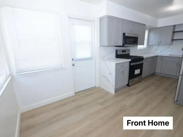 a kitchen with granite countertop a refrigerator and a stove top oven