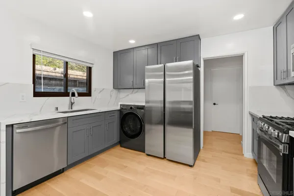 a kitchen with stainless steel appliances granite countertop a refrigerator sink and stove