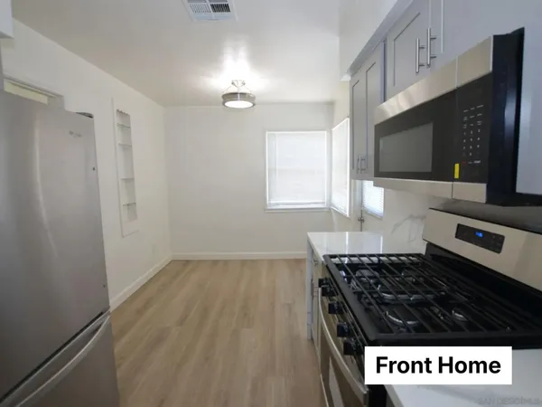 a kitchen with granite countertop a stove and a microwave