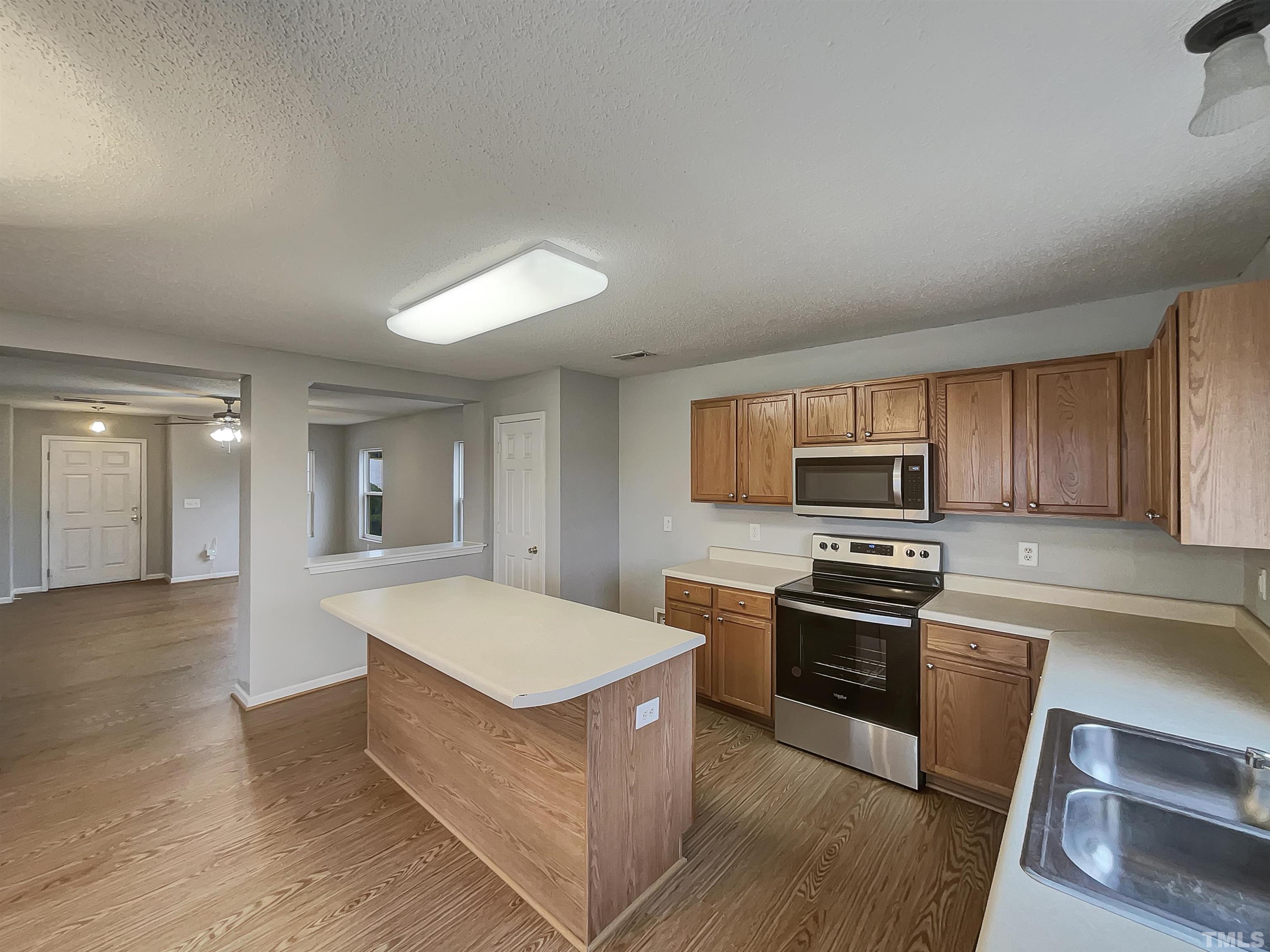 6036 Namozine Court Raleigh, NC 27610 - Photo 11 of 19 a kitchen with stainless steel appliances granite countertop a stove a sink and a refrigerator