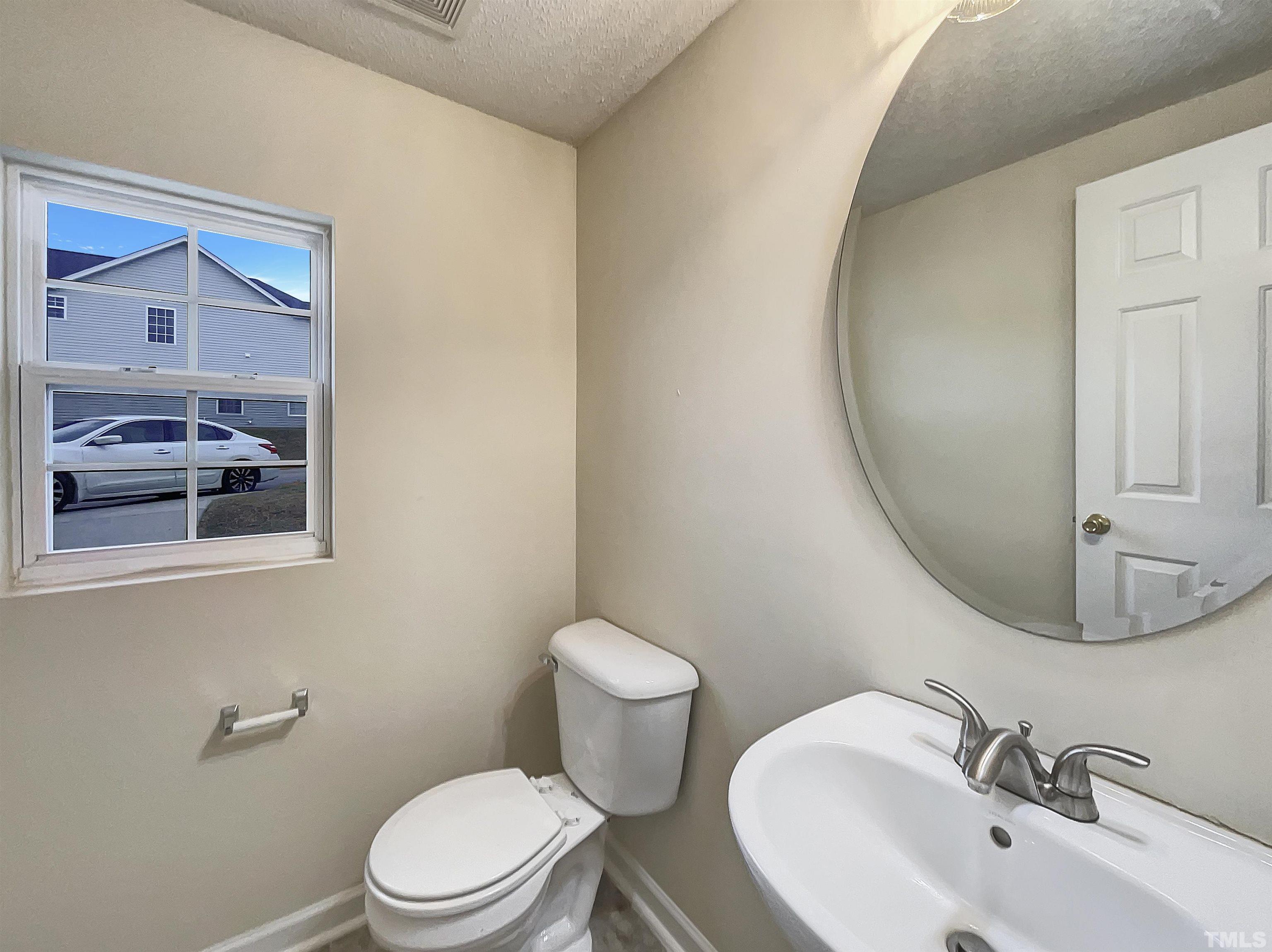 6036 Namozine Court Raleigh, NC 27610 - Photo 12 of 19 a bathroom with a sink mirror and toilet