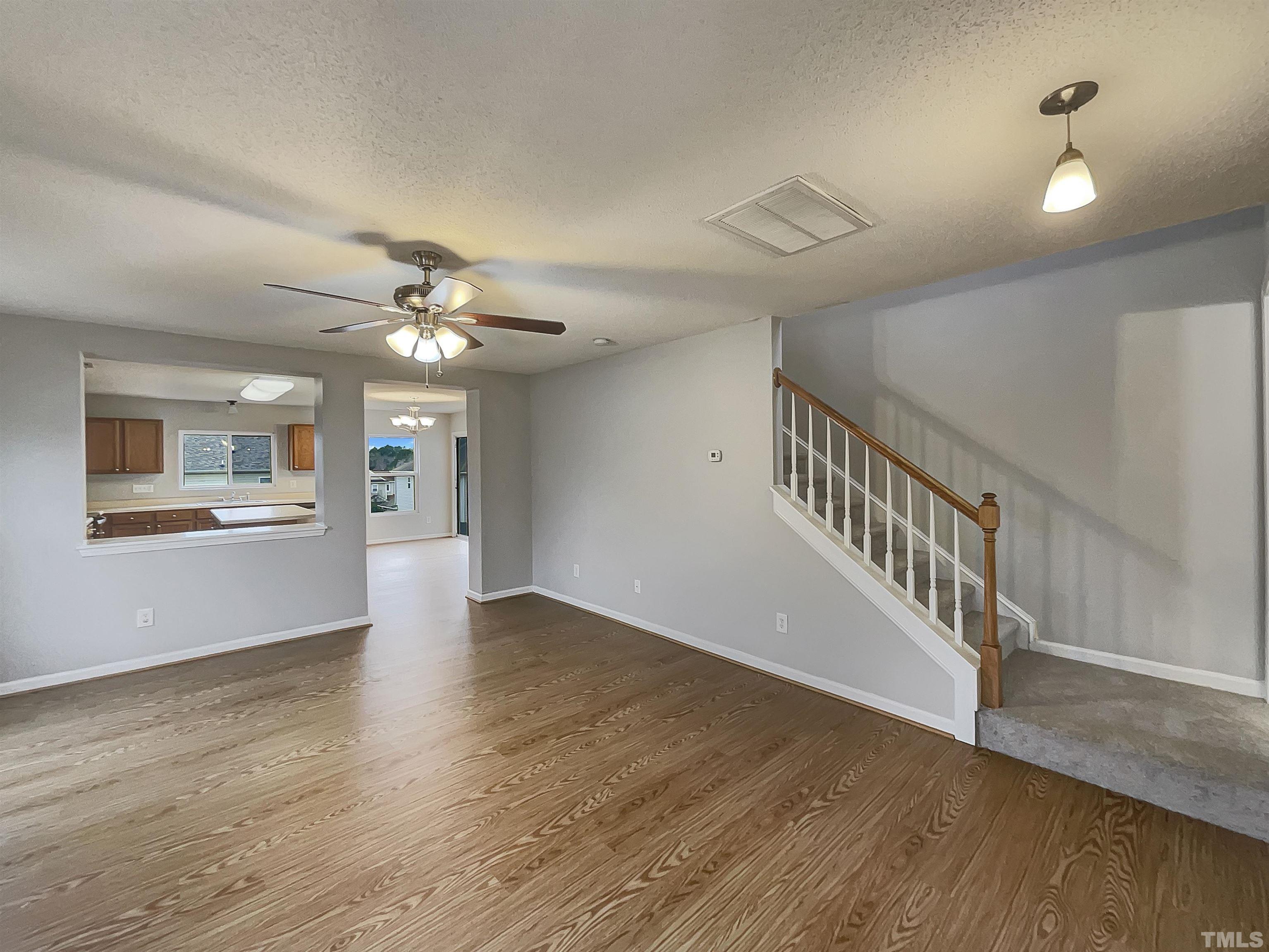 6036 Namozine Court Raleigh, NC 27610 - Photo 6 of 19 a view of an empty room with wooden floor and a ceiling fan