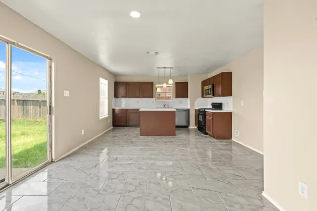 a large room with kitchen island a large window and a couch