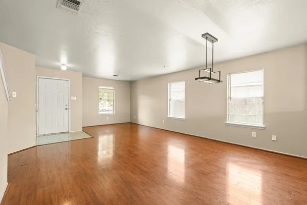 a view of empty room with wooden floor and window
