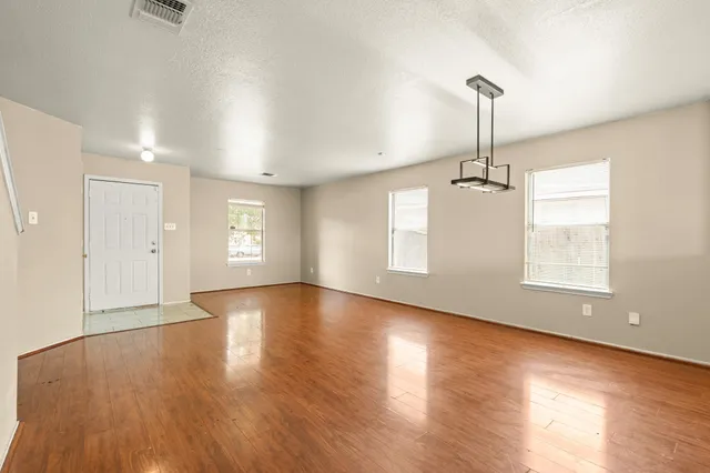 a view of empty room with wooden floor and window