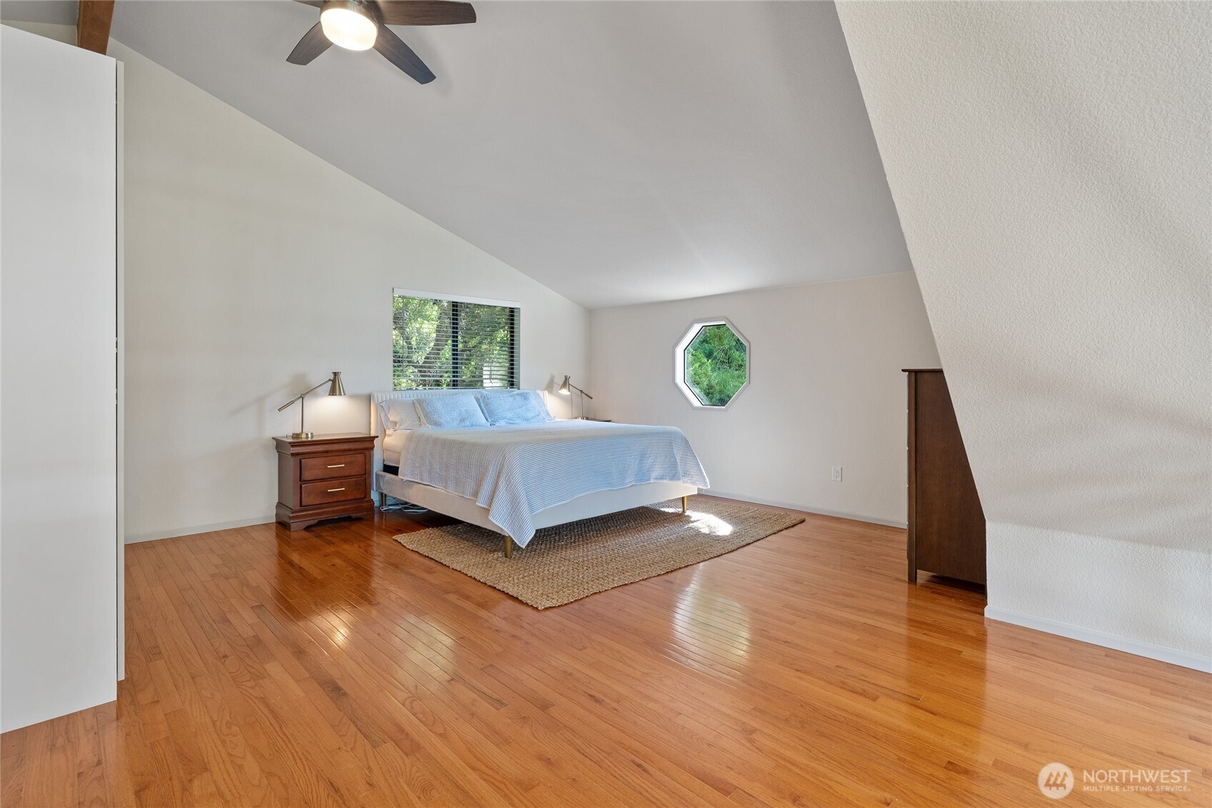 19709 Whiteman Cove Road Southwest Longbranch, WA 98351 - Photo 19 of 40 a spacious bedroom with a bed and a chandelier