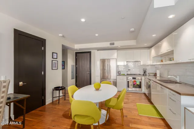 a kitchen with a dining table chairs and white cabinets