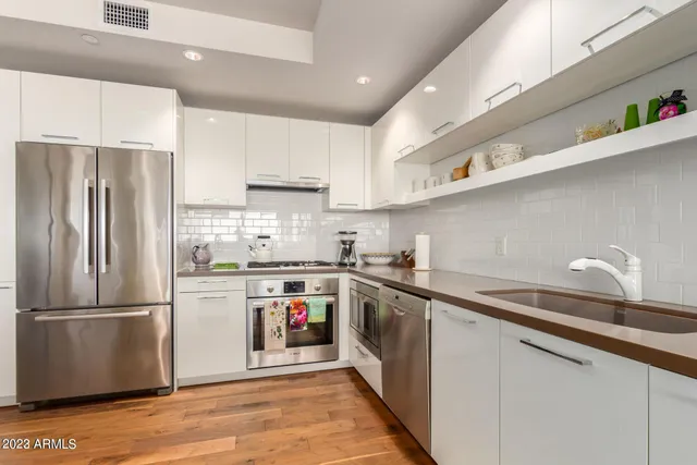 a kitchen with stainless steel appliances a sink stove and refrigerator