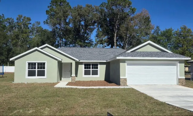 a front view of a house with yard and trees