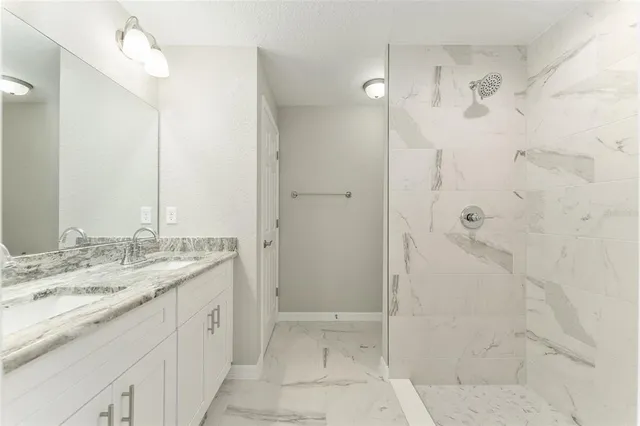 a bathroom with a granite countertop sink a shower and a mirror