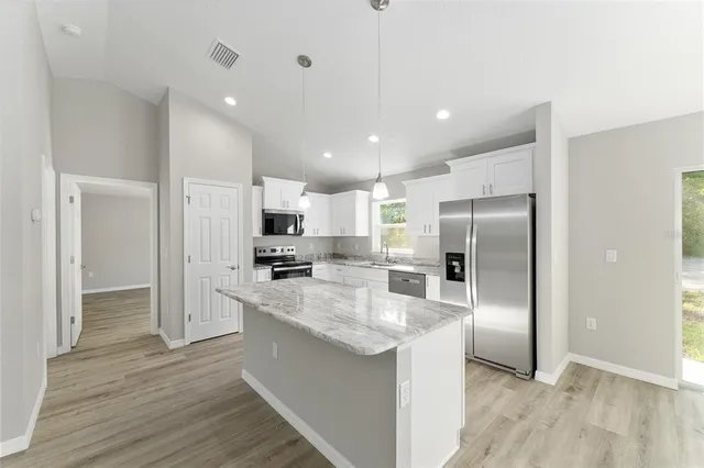 a kitchen with stainless steel appliances a refrigerator sink and microwave