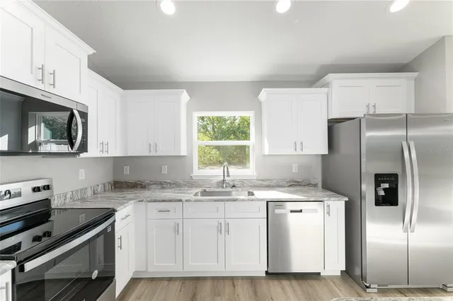 a kitchen with stainless steel appliances granite countertop a refrigerator sink and microwave