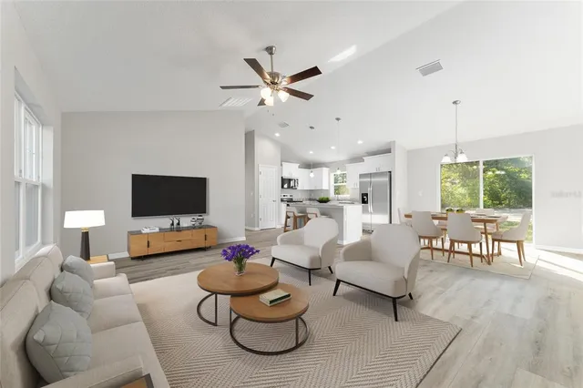 a living room with furniture and a flat screen tv with wooden floor