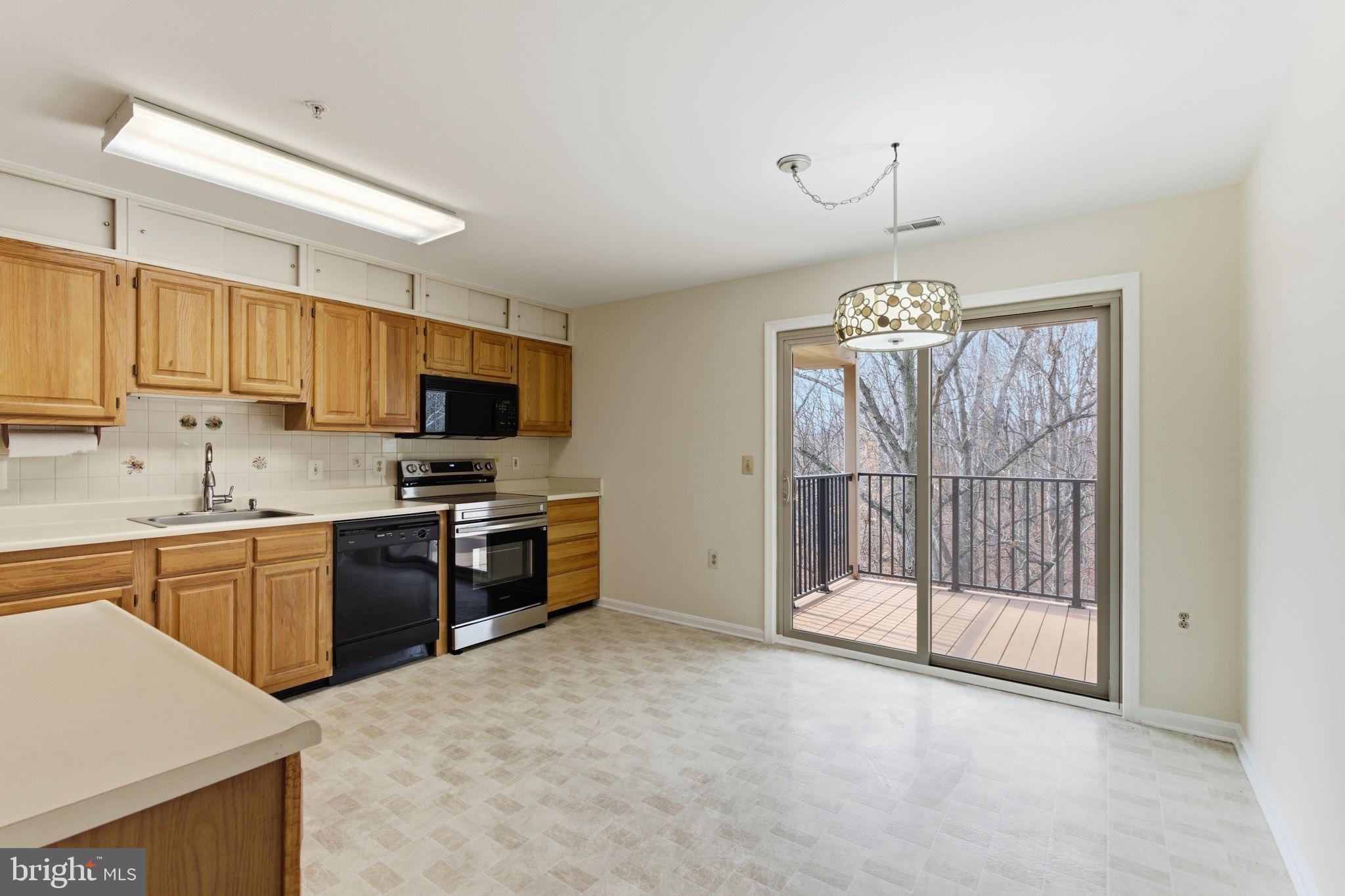 3901 Darleigh Road, Unit 3G Baltimore, MD 21236 - Photo 12 of 41 a kitchen with granite countertop a stove top oven a sink dishwasher a dining table and chairs with wooden floor