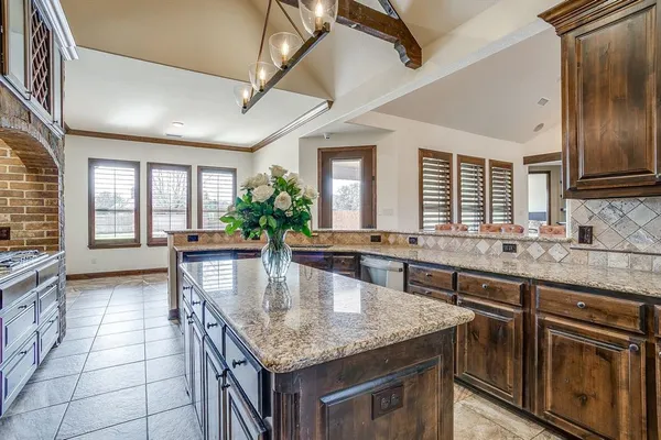 a kitchen with granite countertop a stove and cabinets