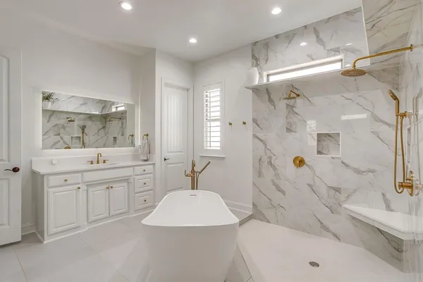 a spacious bathroom with a double vanity sink mirror and bathtub