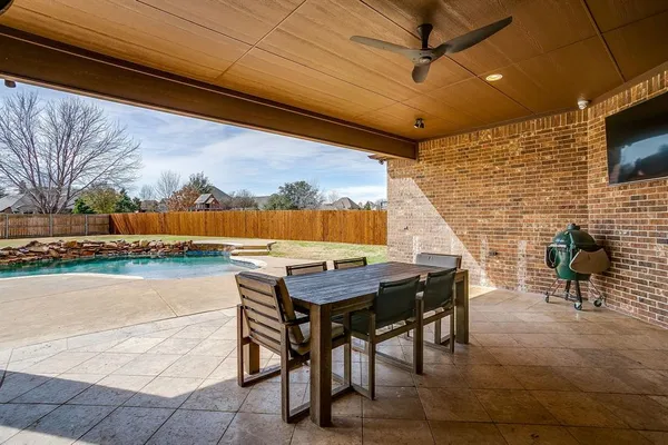 a view of swimming pool with lawn chairs and large trees