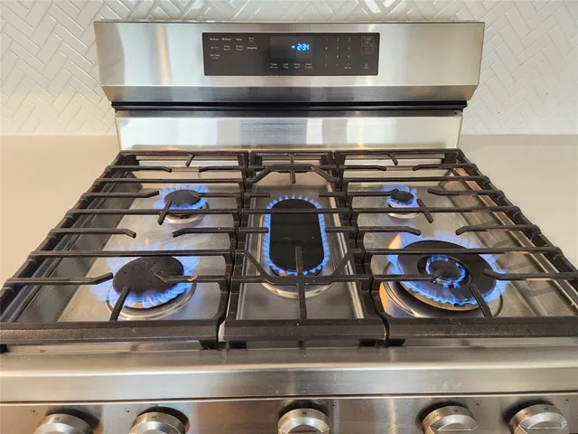 a view of a kitchen with kitchen island wooden floor appliances and a ceiling fan