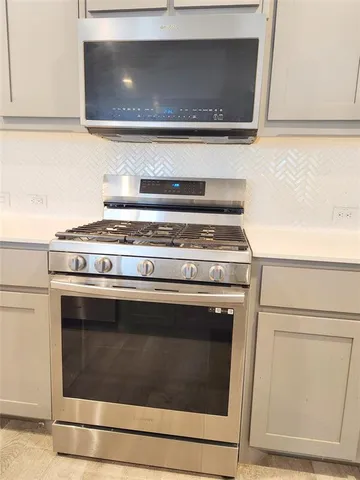 an empty room with wooden floor ceiling fan and windows