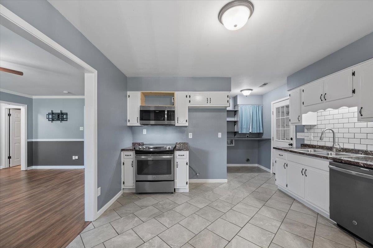 9496 Holly Grove Road Brighton, TN 38011 - Photo 12 of 29 Kitchen featuring appliances with stainless steel finishes, white cabinetry, open shelves, and dark stone countertops