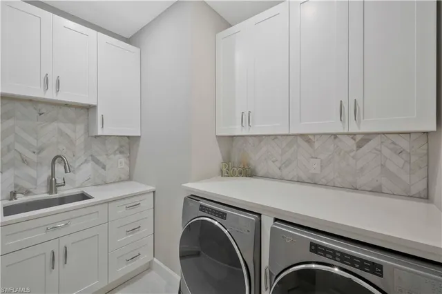 a utility room with sink dryer and washer