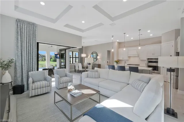 a living room with furniture white walls and a view of kitchen