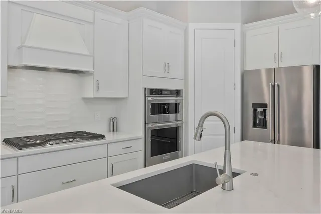 a kitchen with stainless steel appliances granite countertop a refrigerator sink and cabinets