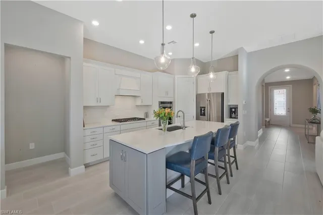a kitchen with a dining table chairs stainless steel appliances and cabinets