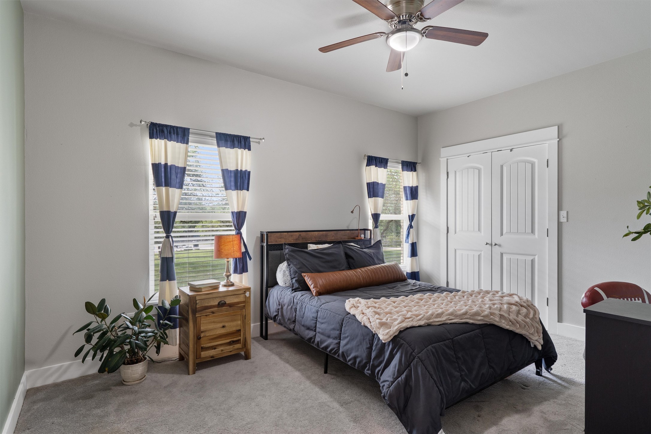 13105 Rooster Springs Road Austin, TX 78737 - Photo 16 of 38 This room features light gray walls, a ceiling fan with integrated lighting, and two windows with blinds and striped curtains