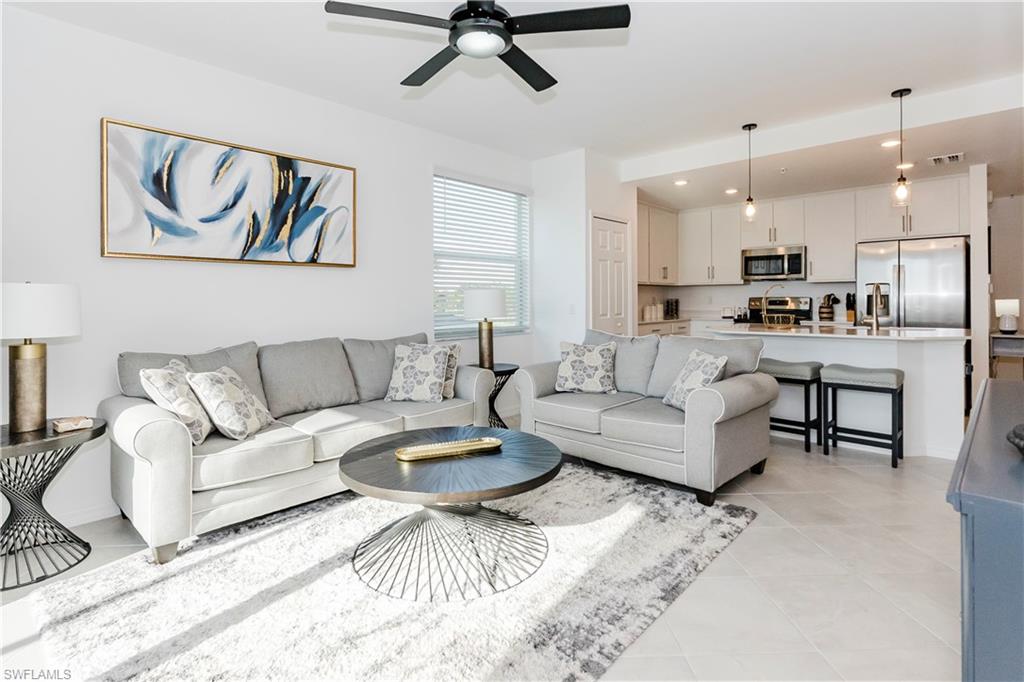 43993 Boardwalk Loop, Unit 1928 Babcock Ranch, FL 33982 - Photo 5 of 50 a living room with furniture and a dining table with kitchen view