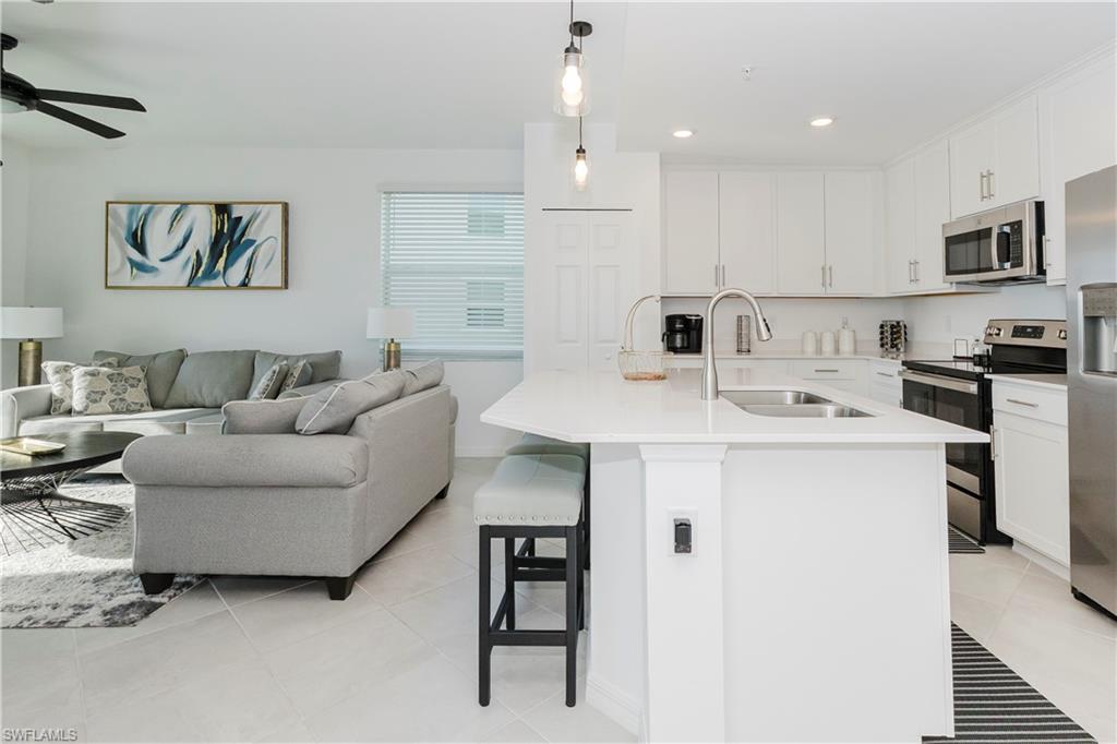 43993 Boardwalk Loop, Unit 1928 Babcock Ranch, FL 33982 - Photo 10 of 50 a living room with stainless steel appliances kitchen island a table and chairs
