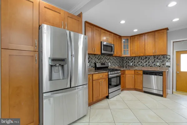 a kitchen with stainless steel appliances granite countertop a refrigerator and a stove top oven