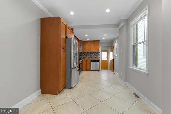 a view of a electric appliances in kitchen and empty room with windows