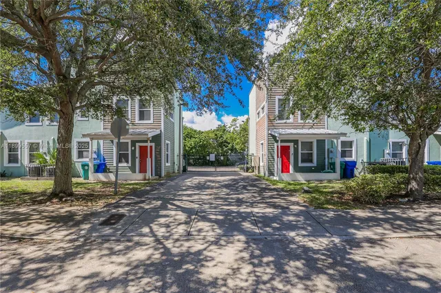a view of road with large trees and a big yard