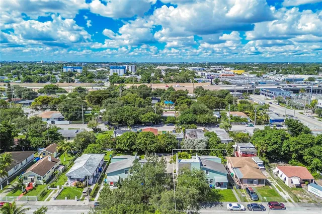 an aerial view of residential houses with outdoor space and parking
