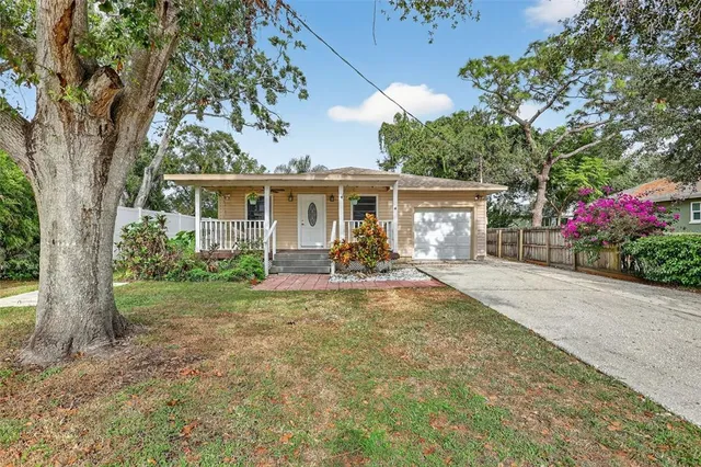 a view of a house with backyard and a tree
