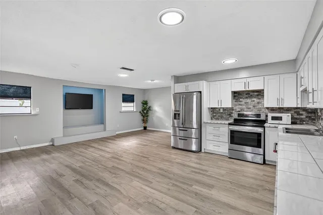 a kitchen with stainless steel appliances a refrigerator and a stove top oven