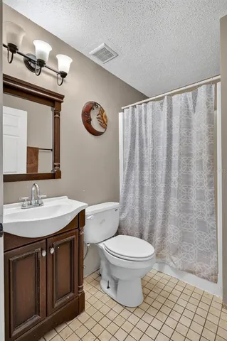 a bathroom with a sink a toilet a mirror and shower curtain