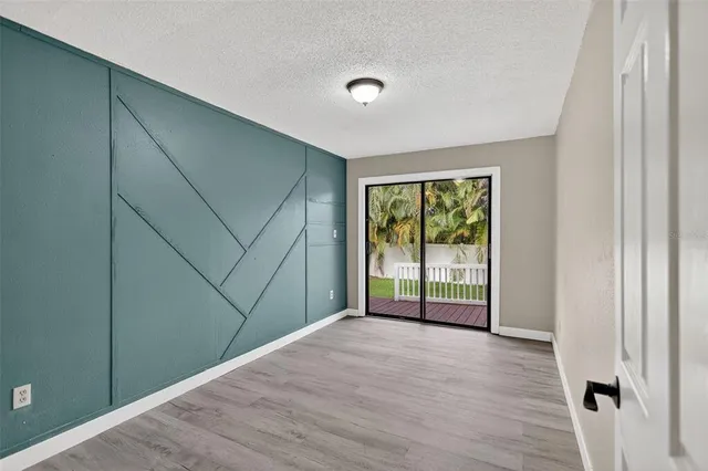 a view of a room that has wooden floor and front door
