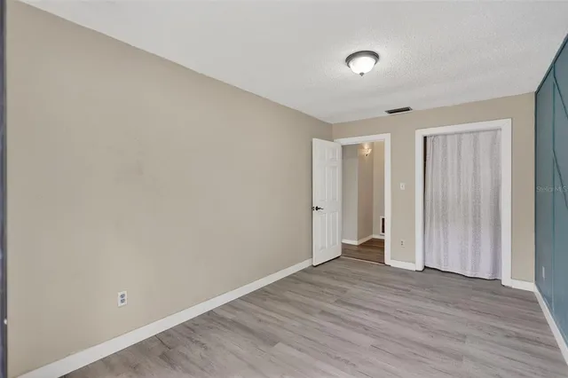 a view of an empty room with wooden floor